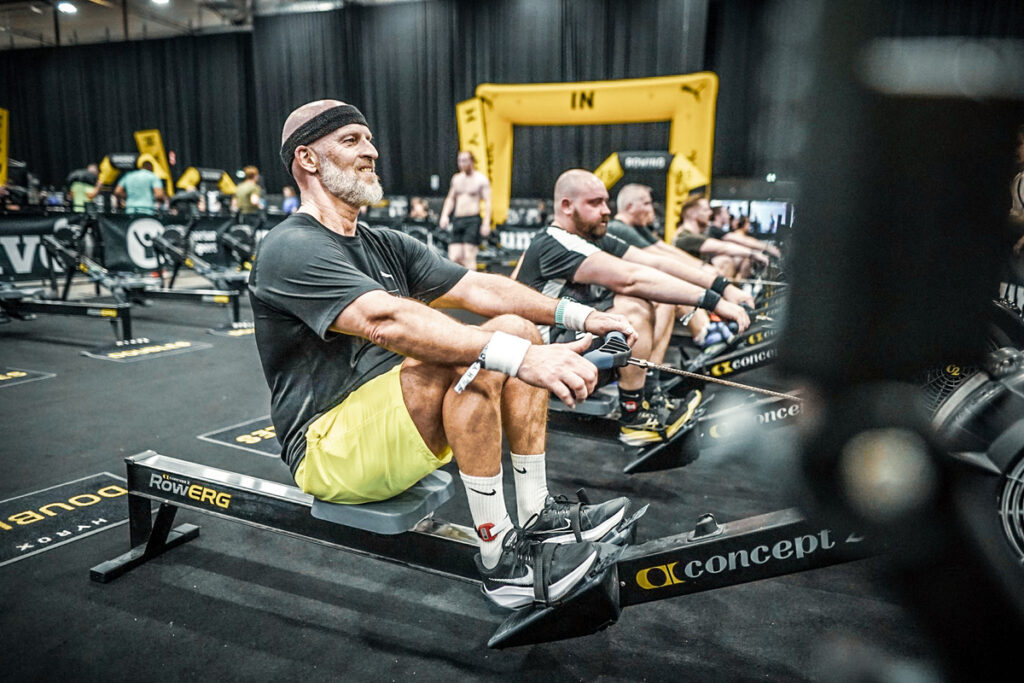 Des hommes réalisant un 1000m rameur lors d'une course Hyrox.