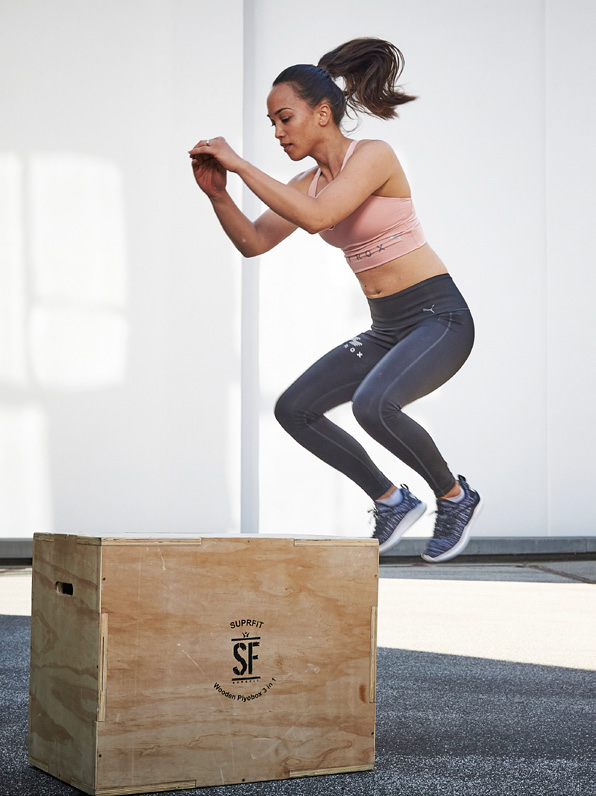 Une femme réalisant des burpee box jumps à la place des burpee broad jumps pendant son entraînement Hyrox.